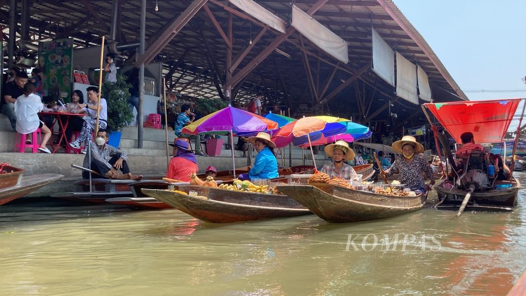 Seorang pengunjung menaiki perahu menuju Pasar Terapung Damnoen Saduak di Provinsi Ratchaburi, Thailand, Senin (27/3/2023). Pasar ini muncul setelah Raja Rama IV memerintahkan pembuatan kanal yang menghubungkan Sungai Mae Klong dengan Sungai Tha Chin sekitar 160 tahun lalu.  