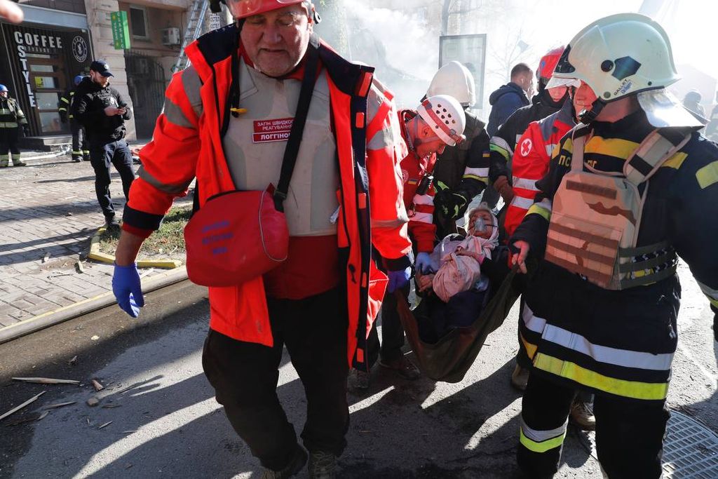Petugas gawat darurat Kyiv, Ukraina mengevakuasi seorang warg sipil di salah satu gedung yang meledak pada Senin (17/10/2022). Gedung itu salah satu sasaran pesawat nirawak berpeledak yang diarahkan Rusia ke sejumlah kota di Ukraina.
