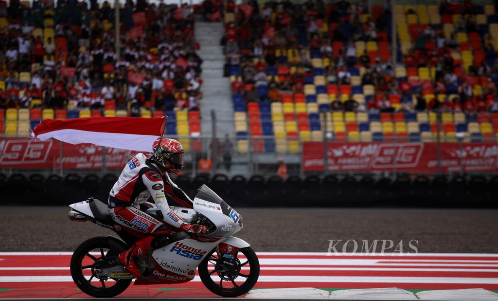 Mario Suryo Aji, pebalap muda Indonesia yang membela tim Moto3 Honda Team Asia, berkeliling Sirkuit Mandalika dengan bendera Merah Putih setelah finis di posisi ke-14 dalam ajang Pertamina Grand Prix of Indonesia di Sirkuit Internasional Jalan Raya Pertamina Mandalika, Lombok Tengah, NTB, Minggu (20/3/2022). Mario pun meraih poin pertamanya di Moto3. 