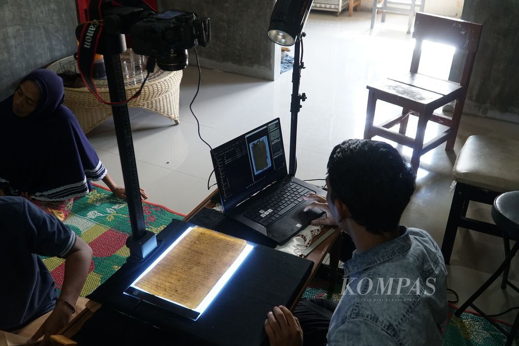 Pegiat konservasi naskah kuno melakukan digitalisasi manuskrip peninggalan Kerajaan Tarusan yang ditulis pada awal dan pertengahan abad ke-19, di Nagari Duku, Kecamatan Koto XI Tarusan, Kabupaten Pesisir Selatan, Sumatera Barat, Kamis (24/3/2022). Upaya digitalisasi naskah kerajaan ini mendesak dilakukan karena kondisinya yang memprihatinkan. Digitalisasi naskah diharapkan pula membuka akses bagi peneliti untuk mengkaji eksistensi kerajaan ini.