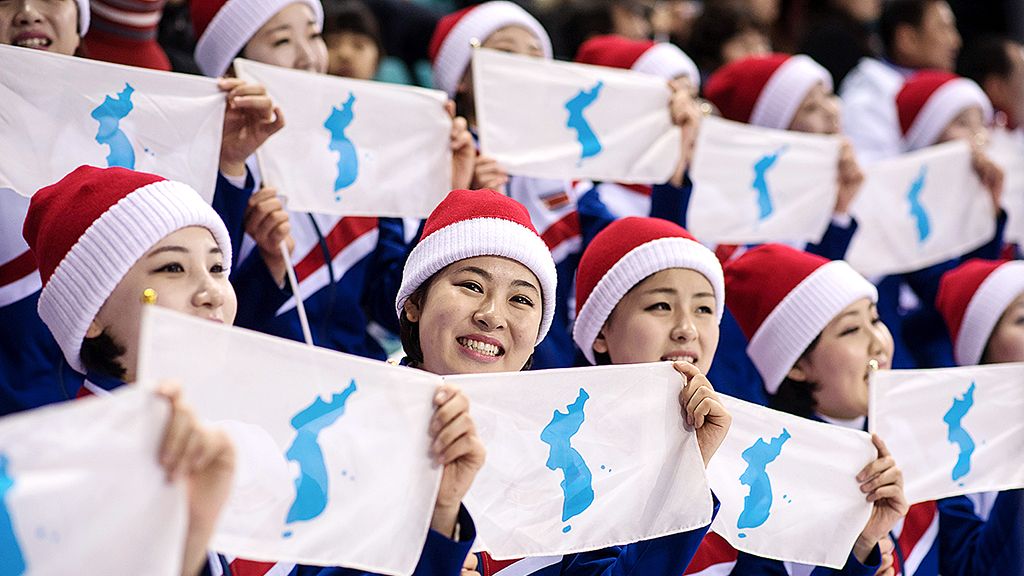 Para perempuan suporter Korea Utara memegang bendera unifikasi Korea dalam laga babak pendahuluan hoki es putri antara tim Korea Bersatu dan Swedia pada Olimpiade Musim Dingin Pyeongchang 2018 di Kwandong Hockey Centre, Gangneung, Korea Selatan, Senin (12/2). 