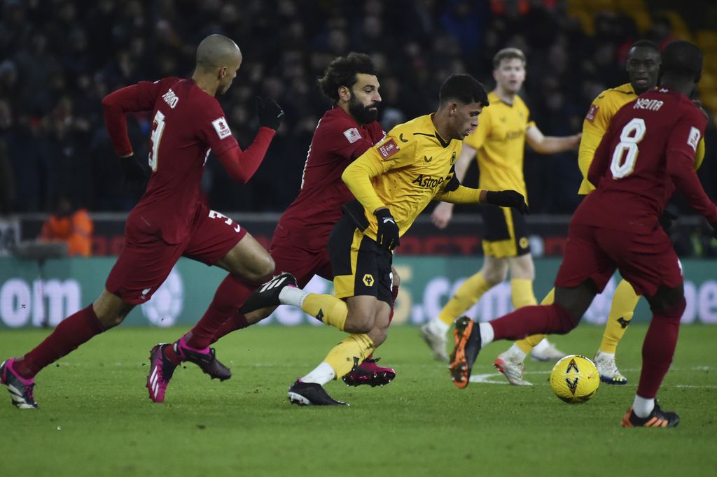 Pemain Wolverhampton Wanderers Matheus Nunes (tengah) berebut bola dengan pemain Liverpool Mohamed Salah dan Fabinho, dalam laga ulangan putaran ketiga Piala FA antara Wolverhampton Wanderers dan Liverpool, Rabu (18/1/2023) dini hari WIB, di Stadion Molineux. 