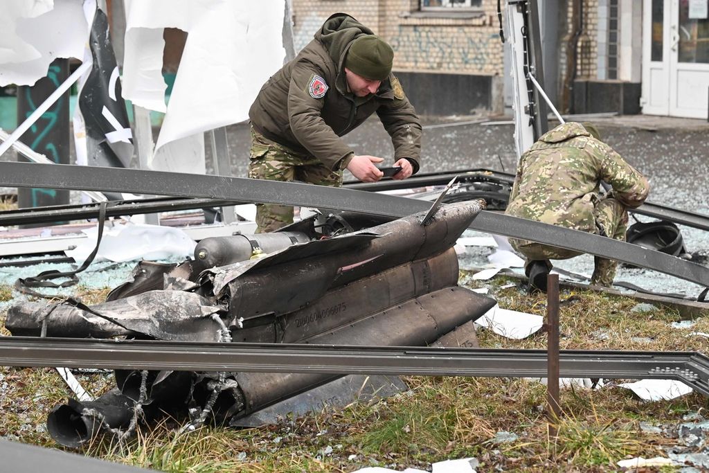 Aparat keamanan Ukraina memeriksa puing-puing rudal Rusia di sebuah jalan di Kiev, Kamis (24/2/2022).