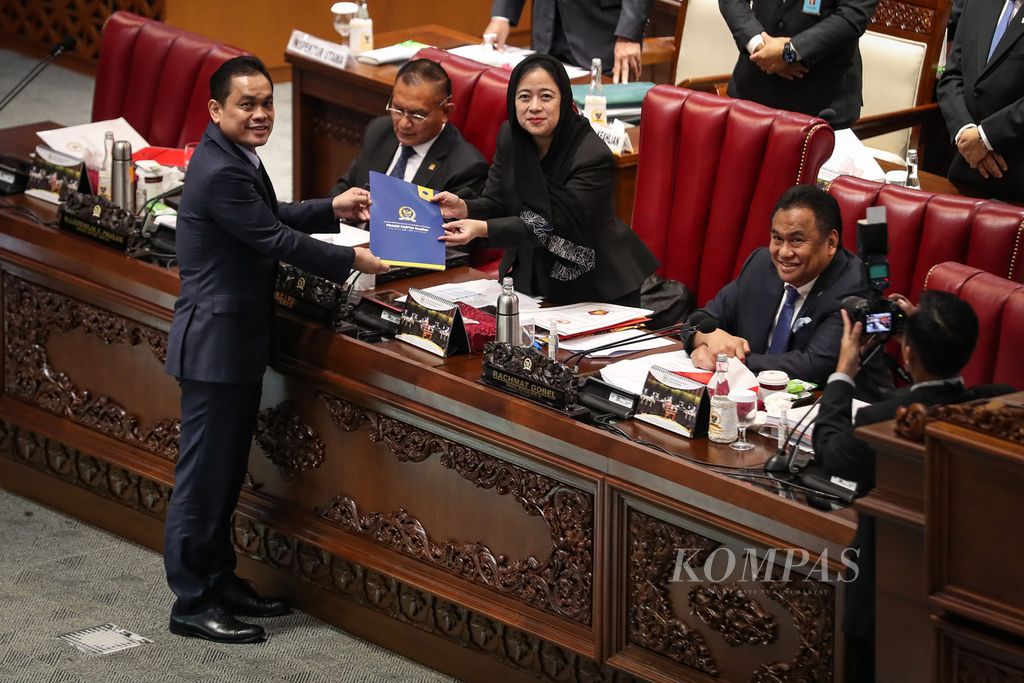 Anggota DPR dari Fraksi Partai Nasdem, Charles Meikyansyah (kiri), menyerahkan berkas pandangan fraksi kepada Ketua DPR Puan Maharani dalam rapat paripurna di Gedung Parlemen, Jakarta, Selasa (11/7/2023). 