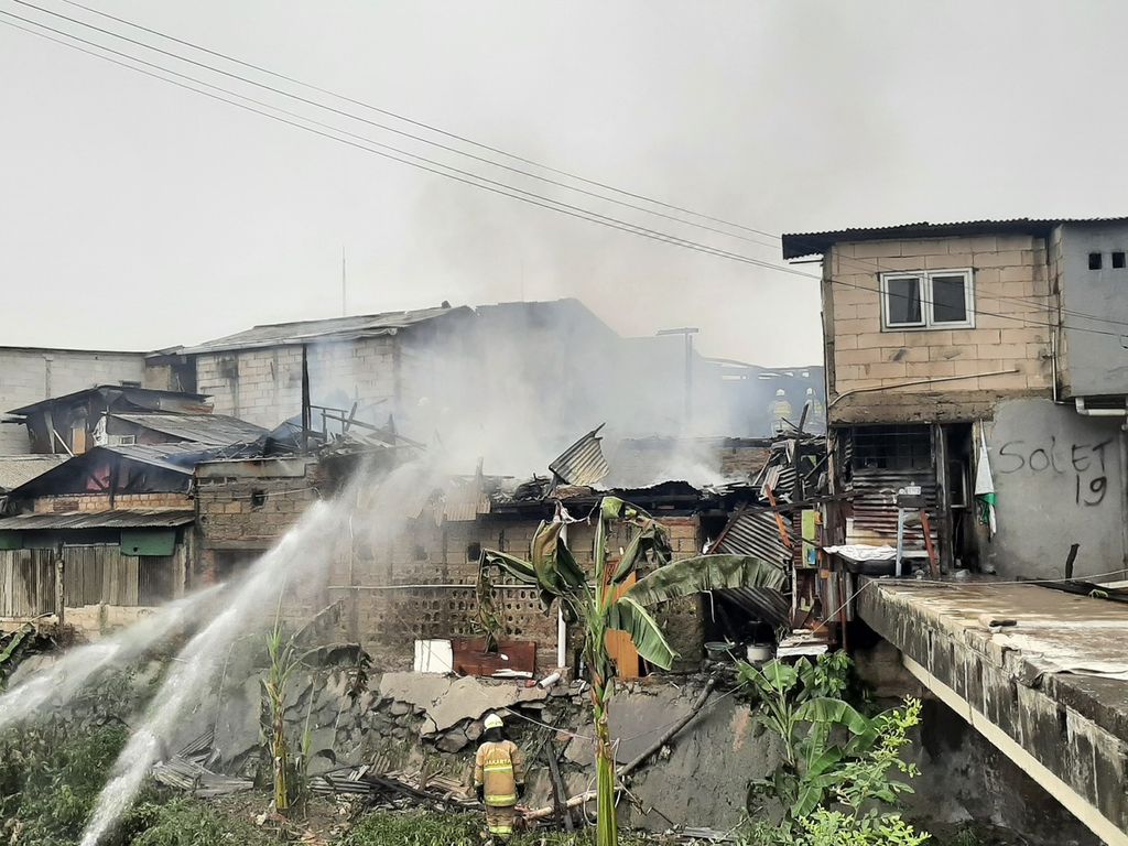 Petugas pemadam kebakaran berusaha memadamkan api di permukiman di Jalan Budi Swadaya, RT 015 RW 004, Kelurahan Kebon Jeruk, Kecamatan Kebon Jeruk, Jakarta Barat, Rabu (19/10/2022).
