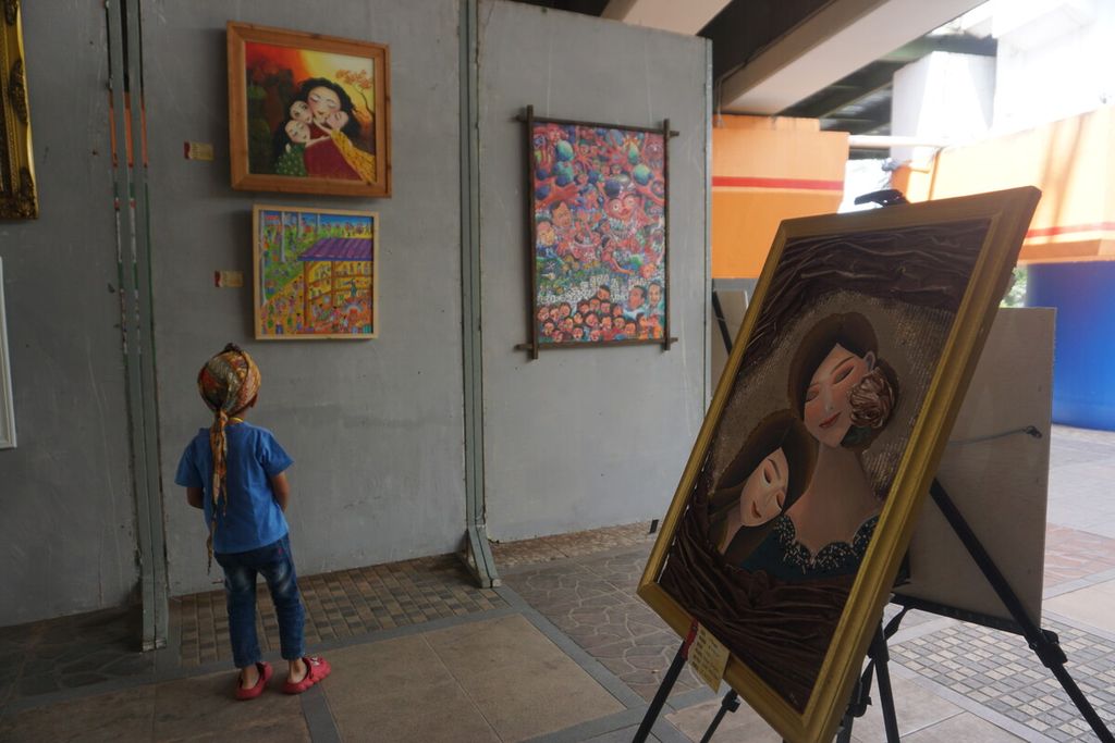 Pengunjung menyaksikan pameran lukisan Dunia Kita, Kanvas Kita di Taman Edukasi Sumber Daya Air di kolong jembatan Jalan Bung Karno, Purwokerto, Banyumas, Jawa Tengah, Minggu (1/10/2023).