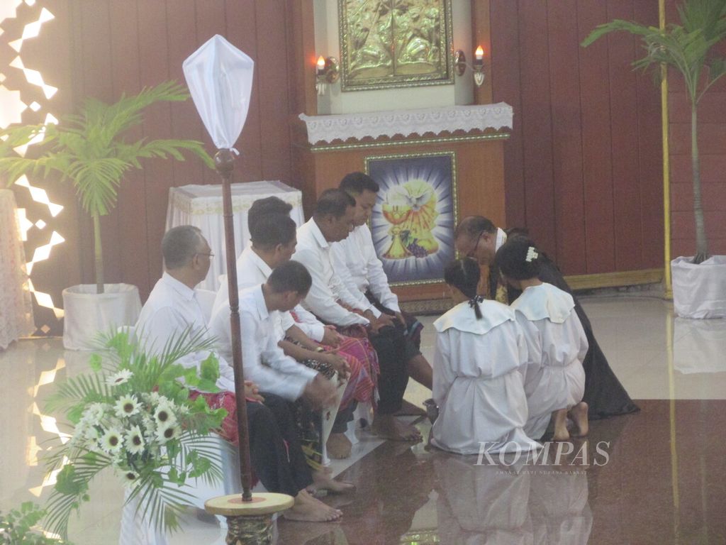 Pastor Dami Lengari OCD pada misa Kamis Putih di Kupang, Kamis (28/3/2024), sedang membasuh kaki rasul-rasul yang diwakilkan 12 umat dari tiap-tiap kelompok umat basis di paroki itu. 