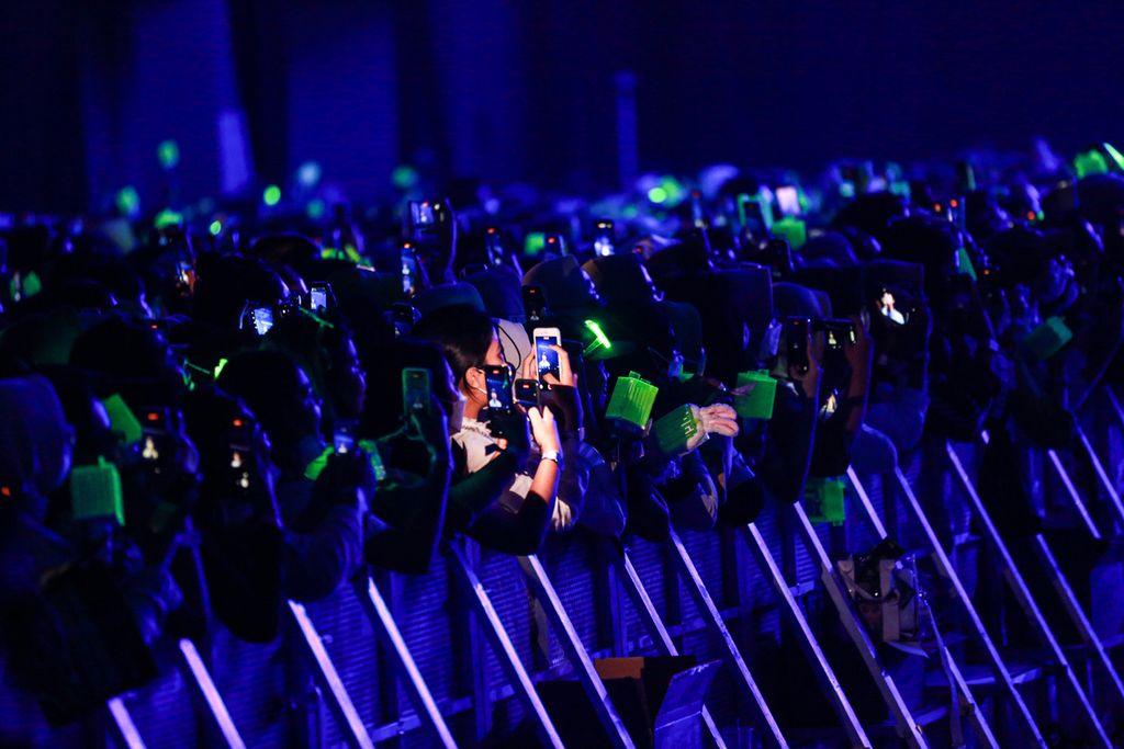 Penonton merekam penampilan boyband asal Korea Selatan NCT 127 di Indonesia Convention Exhibition (ICE), BSD City, Kabupaten Tangerang, Banten, Jumat (4/11/2022) malam. Berbagi konten merlalui media sosial saat menyaksikan konser artis kesayangannya sudah lazim dilakukan.