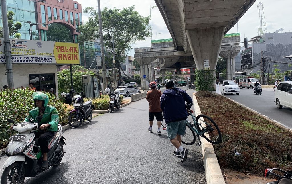 Sejumlah pesepeda melewati jalan yang sebelumnya merupakan jalur pedestrian dan jalur sepeda di simpang Santa, Kebayoran Baru, Jakarta Selatan,  Minggu (16/4/2023). Jalan tersebut dialihfungsikan menjadi jalan pengendara bermotor dari arah Jalan Wolter Monginsidi menuju arah kawasan Blok M.
