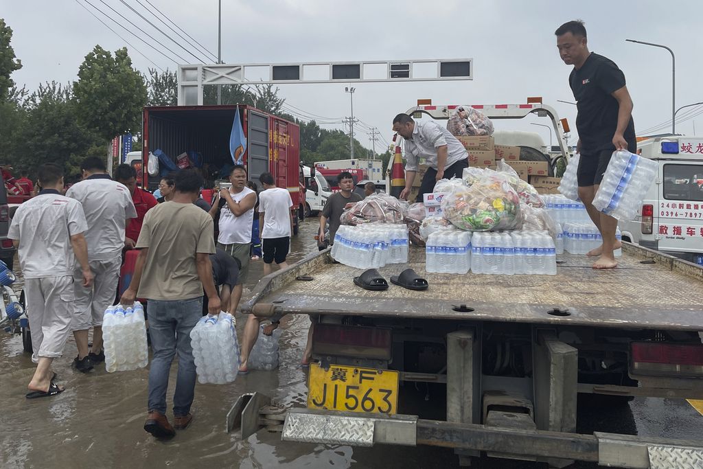 Warga menurunkan bantuan untuk pengungsi akibat banjir di Zhuozhou, Provinsi Hebei, China Rabu (2/8/2023). 