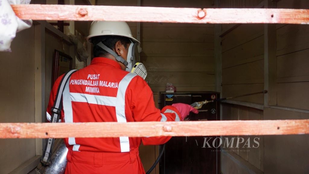 Petugas dari Pusat Pengendalian Malaria Mimika menyemprotkan insektisida pada akhir Februari 2019 di Jalan A Yani, Timika, Papua. 