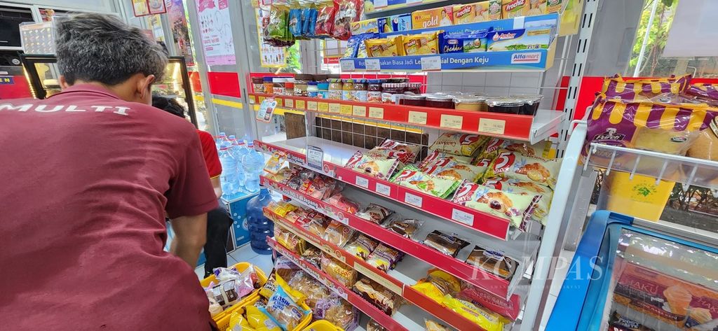 Seorang petugas sedang menata produk roti dalam kemasan di salah satu minimarket di Tangerang Selatan, Banten, Senin (22/7/2024).