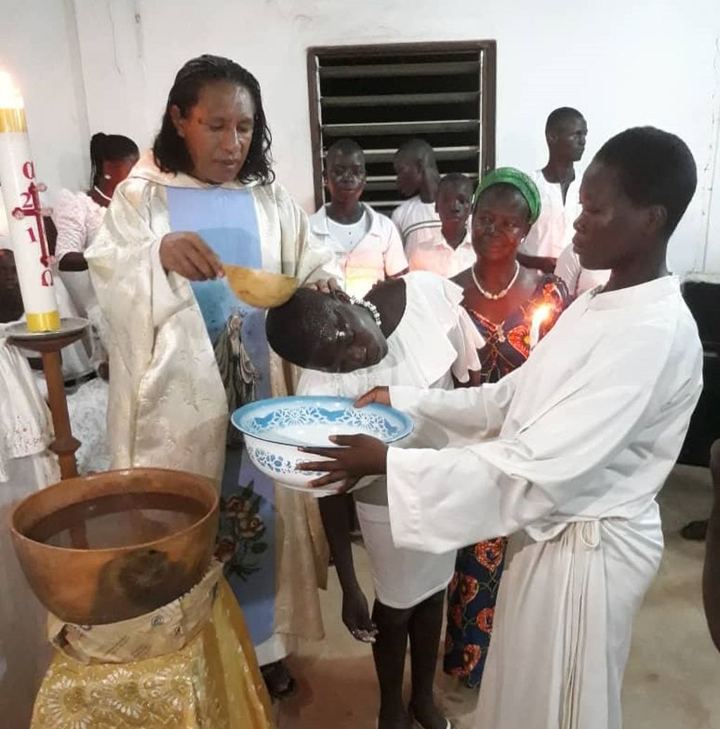 P Marselinus Wangu SVD sedang membaptis anak-anak.