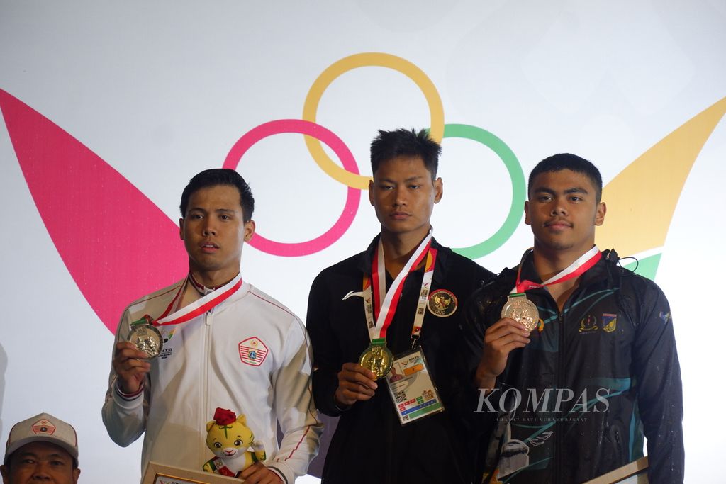 Peraih medali lomba renang putra nomor 50 meter gaya kupu-kupu, Azel Zelmi Aryalingga (kiri), Joe Aditya Kurniawan (tengah), dan Jeremy Elyon Masterganesha Damanik (kanan) berpose saat upacara pengalungan medali di Kolam Renang Selayang, Kota Medan, Minggu (15/9/2024) malam.