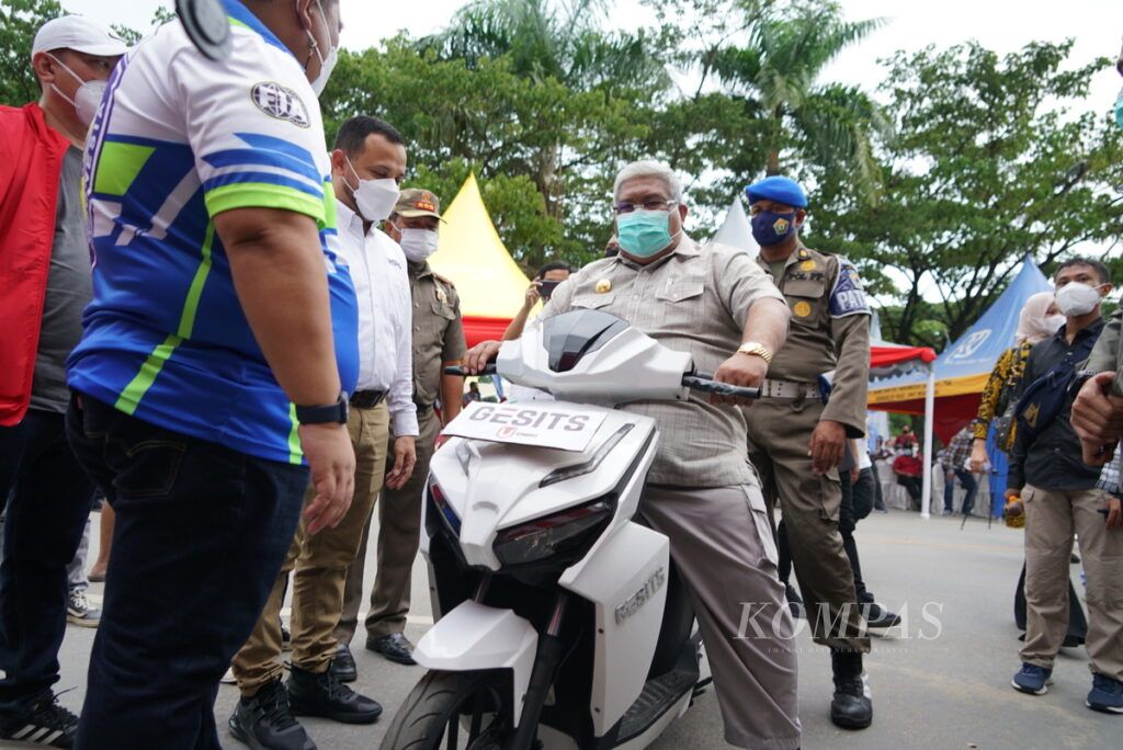 Gubernur Sultra Ali Mazi mengcek motor listrik Gesits yang pertama kali diresmikan di Indonesia Timur, di Kendari, Sulawesi Tenggara, Sabtu (27/2/2021). Pemerintah Provinsi Sultra mendorong adanya industri perakitan kendaraan listrik di daerah kaya nikel ini.
