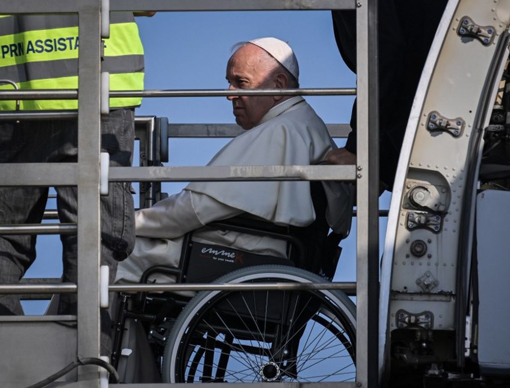 Paus Fransiskus naik ke pesawatnya dari lift yang dirancang untuk penumpang dengan mobilitas terbatas, 24 Juli 2022 di Bandara Fiumicino Roma, saat ia memulai lawatan ke Kanada. Paus duduk di kursi roda akibat cidera lutut yang sebelumnya telah membatalkan lawatannya ke RD Kongo dan Sudan Selatan, Juni lalu. 