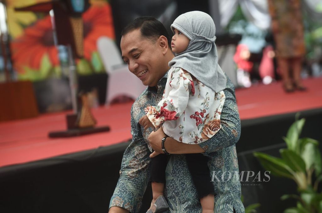 Dengan membawa anak dari peserta, Wali Kota Surabaya Eri Cahyadi maju ke panggung saat wisuda Sekolah Orang Tua Hebat Surabaya di halaman Balai Kota Surabaya, Selasa (3/9/2024). 