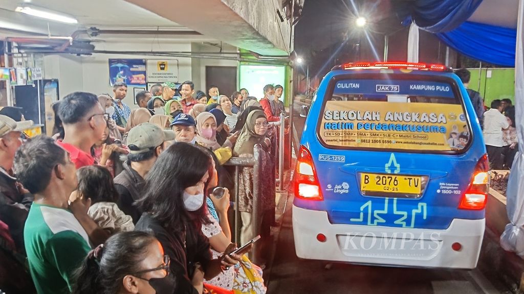 Warga menanti kedatangan mikrotrans di titik pemberhentian Pusat Grosir Cililitan, Jakarta Timur, Jumat (31/1/2024). Salah satu rute mikrotrans 24 jam yaitu Jak 75 dengan rute Cililitan-Kampung Pulo.