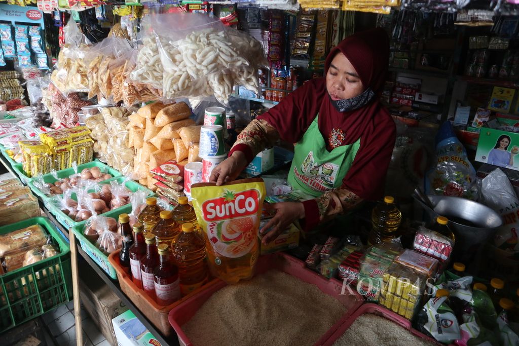 Pedagang melayani pembeli minyak goreng di Pasar Kramat, Kota Cirebon, Jawa Barat, Kamis (20/1/2022). Pemerintah menetapkan satu harga minyak goreng Rp 14.000 per liter. Namun, di sejumlah pasar di Cirebon, harganya masih Rp 18.500-Rp 20.000 per liter.