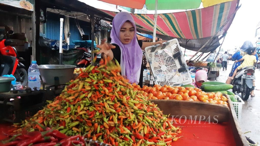 Salah satu pedagang cabai rawit di Pasar Besar Palangkaraya, Kalimantan Tengah, mengatur dagangannya, Minggu (26/12/2021).