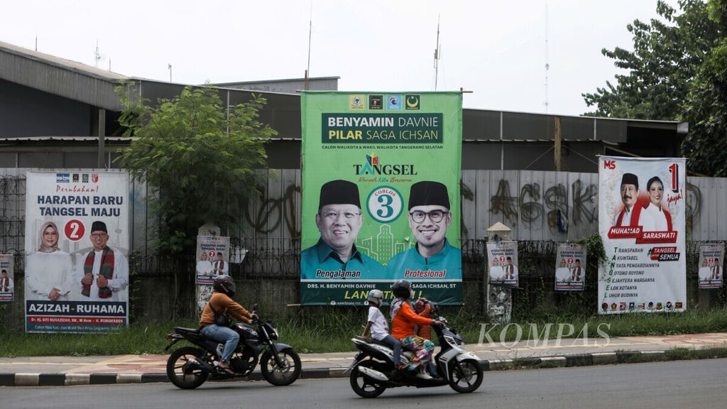 Pengendara sepeda motor melintas di depan baliho kampanye tiga pasangan calon wali kota-wakil wali kota Tangerang Selatan di Jalan Tekno Widya, Tangerang Selatan, Jumat (13/11/2020). Masa kampanye berlangsung hingga 5 Desember 2020, masa tenang 6-8 Desember, sedangkan pemungutan suara pada 9 Desember 2020.