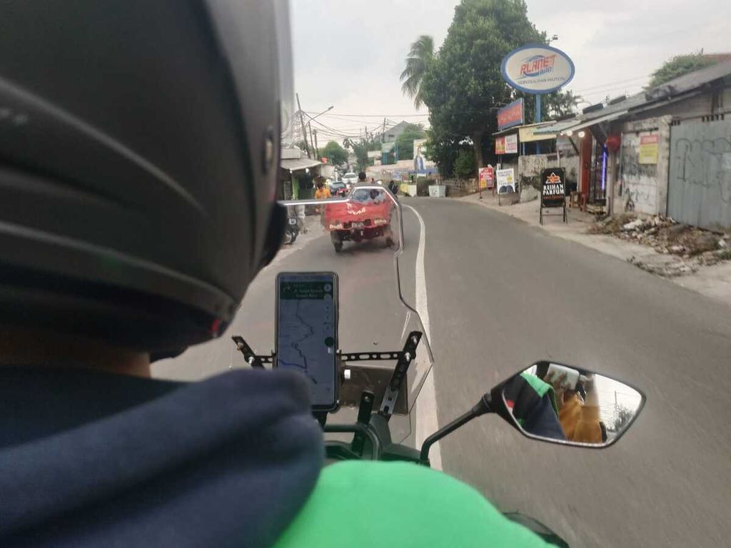 Salah satu pengemudi ojek daring di Ciledug, Tangerang, sedang mengantarkan penumpang, Rabu (7/6/2023).