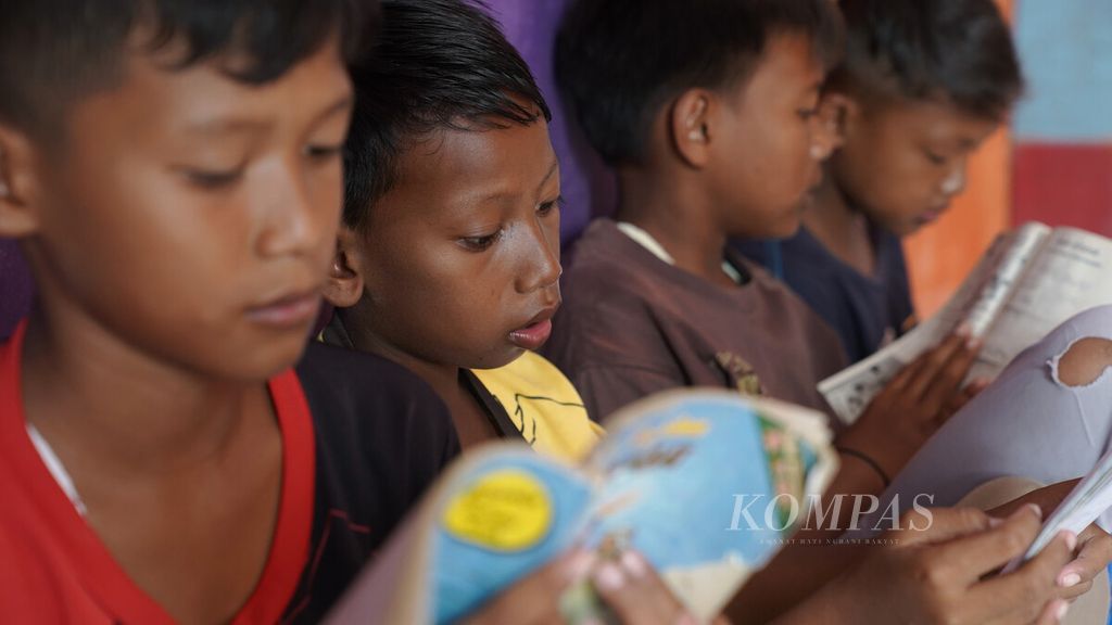 Anak-anak membaca buku koleksi perpustakaan di Rumah Belajar Anak Bintang di Desa Pantai Mekar, Kecamatan Muaragembong, Kabupaten Bekasi, Jawa Barat, Rabu (26/10/2022). 