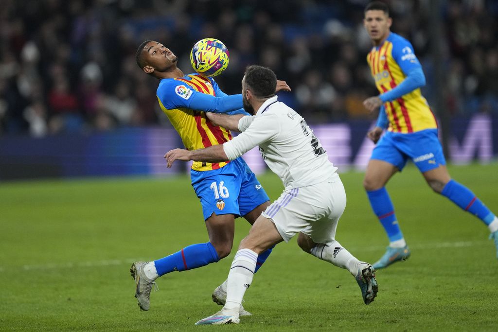 Pemain Valencia, Samuel Lino (kiri), berebut bola dengan pemain Real Madrid, Dani Carvajal, dalam pertandingan sepak bola Liga Spanyol di Stadion Santiago Bernabeu di Madrid, Spanyol, Kamis (2/2/2023). Real menang, 2-0.