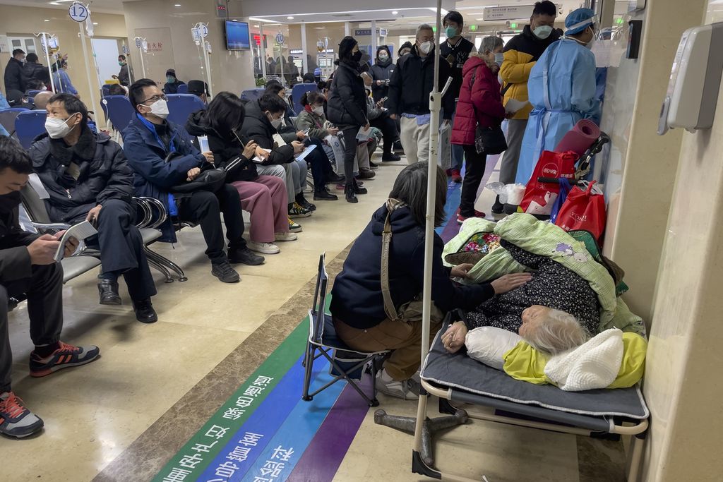 Seorang perempuan merawat kerabat lansianya yang terbaring di tandu saat menerima infus di bangsal darurat sebuah rumah sakit di Beijing, China, Kamis (5/1/2023). Pasien, kebanyakan dari mereka lanjut usia, berbaring di tandu di lorong dan harus menerima oksigen sambil duduk di kursi roda. 