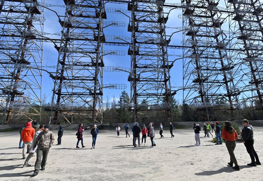 Sejumlah warga berdiri menyaksikan bagian dari sisa sistem radar Duga-1 yang sudah tidak terpakai yang dibangun Uni Soviet di dekat Chernobyl, Ukraina, Sabtu (24/4/2021). 