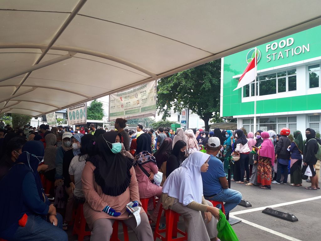 Residents line up waiting for their turn to take aid at the Tjipinang Raya Food Station, East Pisangan, Pulo Gadung, East Jakarta, Friday (2/12/2022).
