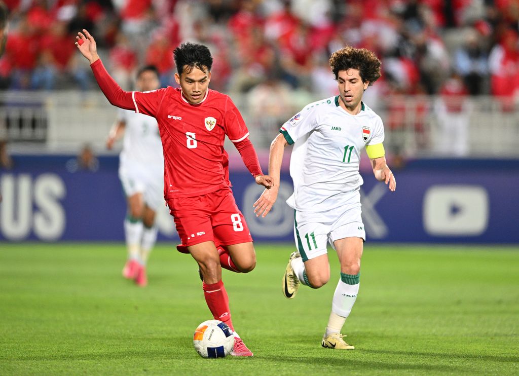 Indonesian player, Witan Sulaeman (left), dribbles the ball while being shadowed by Iraqi player, Muntadher Mohammed Maslookhi, in the match for third place in the U-23 Asia Cup at Abdullah bin Khalifa Stadium, Doha, Thursday (5/2/2024).
