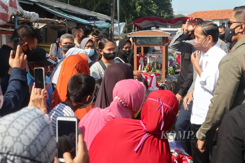 Presiden Joko Widodo (baju putih) menyalami sejumlah pedagang di Pasar Harjamukti, Kota Cirebon, Jawa Barat, Rabu (13/4/2022). Selain menyalurkan bantuan kebutuhan pokok kepada warga, Presiden juga memberikan bantuan modal usaha kepada pedagang setempat. Bantuan itu diharapkan meringankan beban masyarakat kecil.