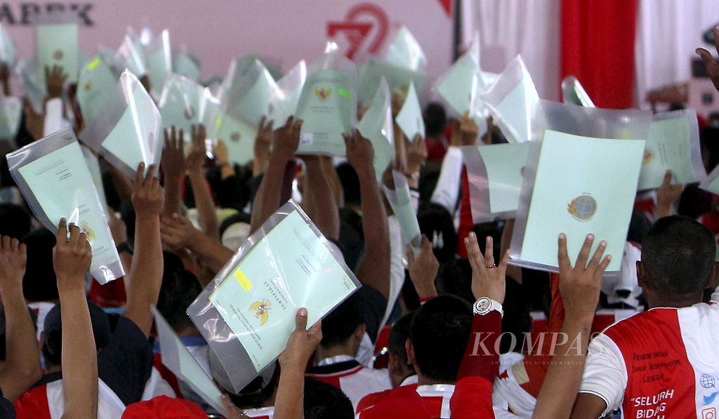 Sejumlah warga memegang sertifikat tanah miliknya saat penyerahan sertifikat hak atas tanah se-Jabodetabek di Jakarta, Minggu (20/8/2017). Pemerintah menyerahkan 7.486 sertifikat hak atas tanah kepada warga Jabodetabek. 