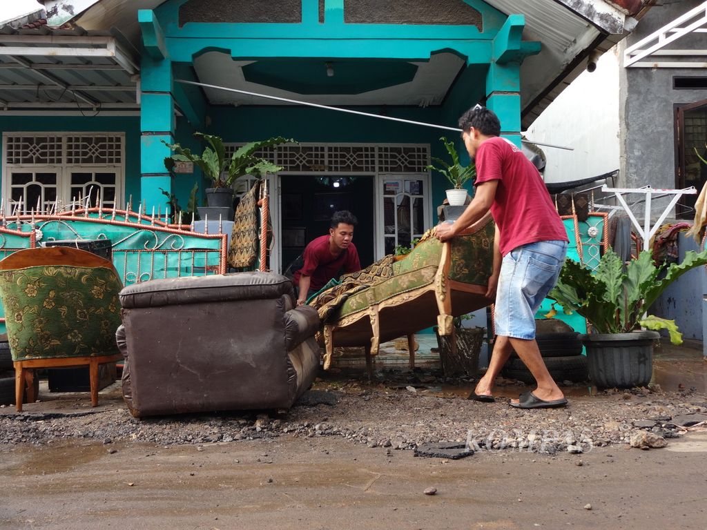 Warga yang terdampak banjir di Kelurahan Rajabasa Nunyai, Kecamatan Rajabasa, Kota Bandar Lampung, tampak membersihkan rumah dari lumpur sisa banjir pada Minggu (25/2/2024) pagi. Warga masih waspada adanya banjir susulan karena hujan deras masih terus mengguyur sebagian besar wilayah Lampung.