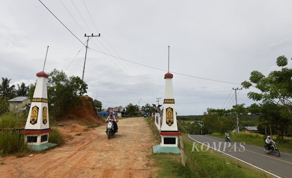 Warga mengendarai sepeda motor meninggalkan gapura di Tugu Perbatasan Garuda Perkasa yang berada di Desa Seberang, Sebatik, Kabupaten Nunukan, Kalimantan Utara, Jumat (15/7/2022). 