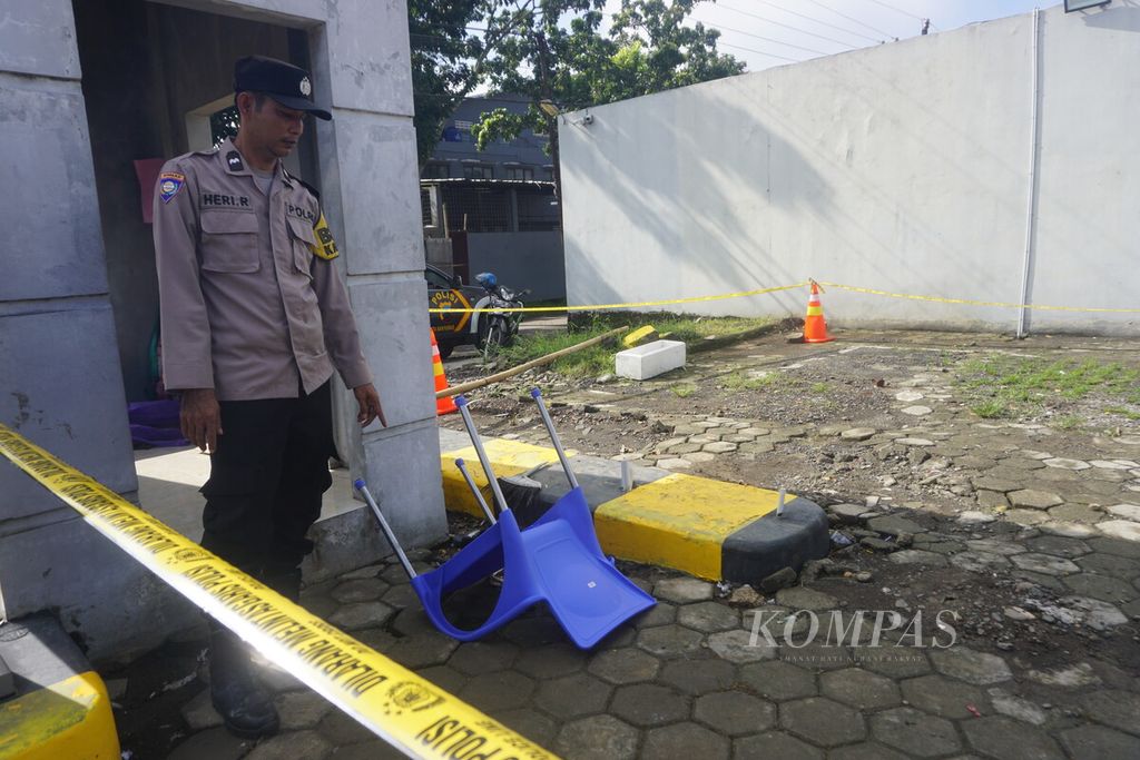 Anggota Kepolisian Resor Kota Banyumas menunjukkan kursi di pos parkir terbalik pascapenembakan juru parkir di Hotel Braga, Sokaraja, Banyumas, Jawa Tengah, Sabtu (27/4/2024). Seorang juru parkir di sana tewas diduga ditembak salah satu pengunjung tempat hiburan hotel tersebut.