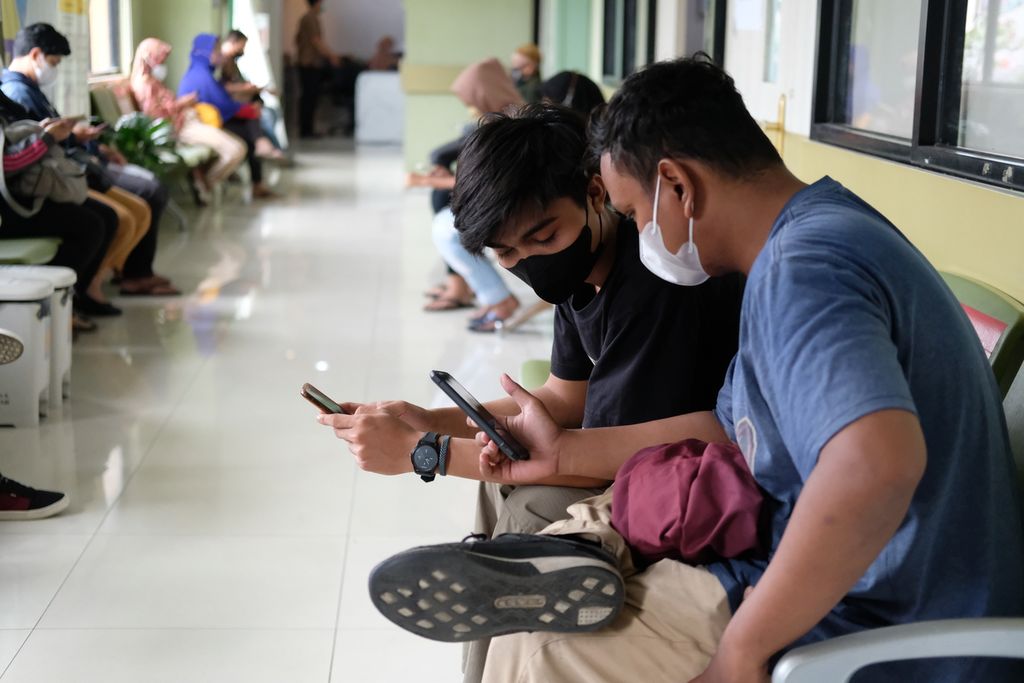 Warga menunggu antrean di depan poliklinik umum di Puskesmas Kecamatan Palmerah, Jakarta Barat, Jumat (21/10/2022). Badan Penyelenggara Jaminan Sosial (BPJS) Kesehatan menerapkan pendaftaran secara daring dengan menggunakan aplikasi Jaminan Kesehatan Nasional (JKN) untuk mempermudah pelayanan. Penggunaan pelayanan secara digital tersebut telah diterapkan di beberapa puskesmas.  