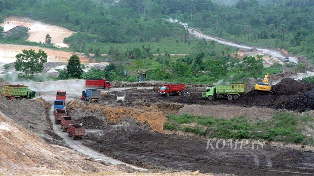 Truk pengangkut batubara hilir mudik di Kecamatan Palaran, Kota Samarinda, Kalimantan Timur, beberapa waktu lalu. Lubang-lubang bekas galian tambang batubara sering kali memakan korban karena dibiarkan terbuka tanpa reklamasi.
