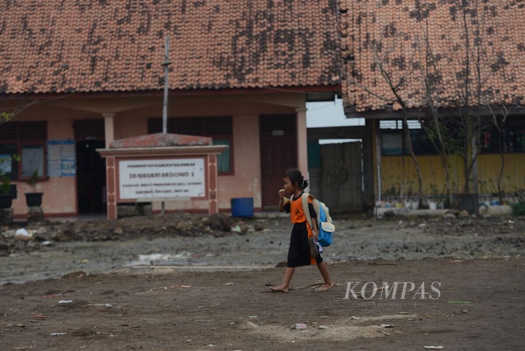 Anak-anak melintasi bangunan sekolahnya yang keberadaannya terancam karena tergerus abrasi di SD Negeri 1 Bedono, Desa Bedono, Kecamatan Sayung, Kabupaten Demak, Jawa Tengah, Jumat (14/6/2019). 