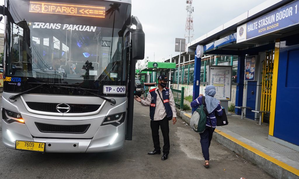 Petugas halte saat mempersilakan calon penumpang naik sarana transportasi Biskita Transpakuan di Halte Stasiun Bogor, Kota Bogor, Jawa Barat, Jumat (12/11/2021). 