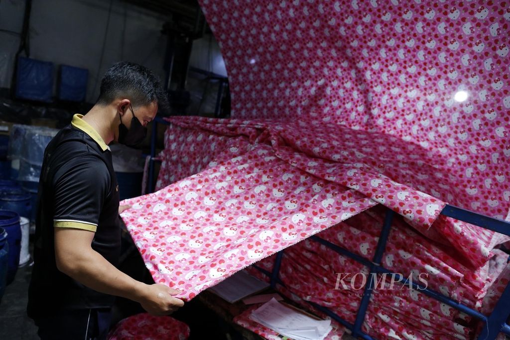 Pekerja pabrik tekstil PT Bentara Sinar Prima di Dayeuhkolot, Kabupaten Bandung, Jawa Barat, memeriksa kain yang sedang diproduksi, 29 Maret 2023. 
