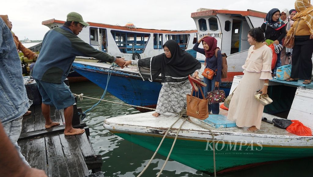 Seorang laki-laki membantu penumpang perempuan turun dari kapal pelayaran rakyat di Dermaga Kayu Bangkoa, Kota Makassar, Sulawesi Selatan, Sabtu (7/4/2018). Pelayaran rakyat menjadi andalan transportasi warga gugusan kepulauan Spermonde di Selat Makassar untuk menghubungkan dengan kota-kota di daratan Sulsel, termasuk Makassar.