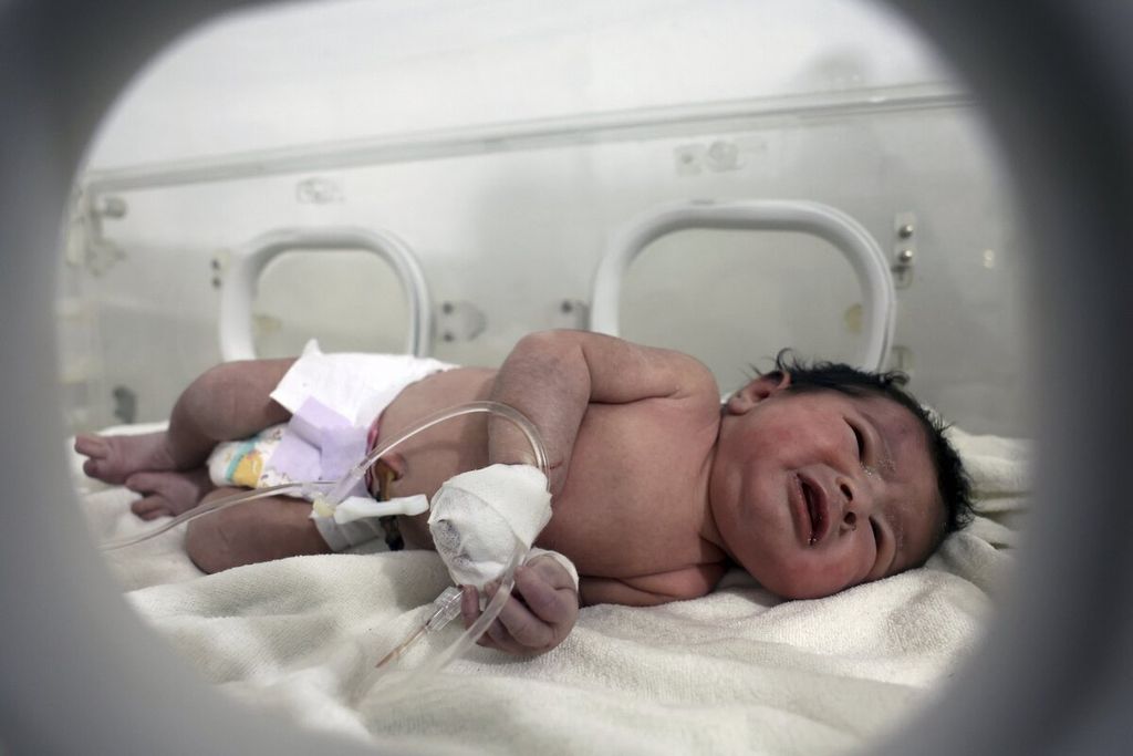 Seorang bayi perempuan menjalami perawatan di inkubator di rumah sakit anak di kota Afrin, Provinsi Aleppo, Suriah, Selasa (7/2/2023). Anak tersebut berhasil dievakuasi dalam kondisi selamat dari bawah puing-puing bangunan menyusul gempa bumi yang mengguncang Suriah dan Turki, Senin (6/2/2023). Saat ditemukan, bayi itu masih terikat tali pusar ibunya yang telah meninggal.