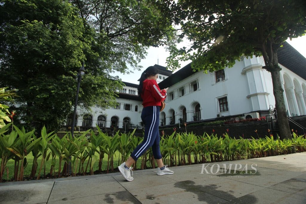 Pengunjung berjalan kaki di halaman belakang Gedung Sate di Kota Bandung, Jawa Barat, Minggu (1/3/2020) pagi. 