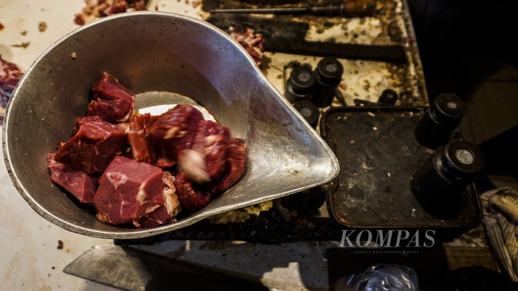 Potongan daging yang dibeli konsumen di kios daging milik Mufid (62) di Pasar Bogor, Kota Bogor, Jawa Barat, saat ditimbang, Rabu (23/2/2022). Kenaikan harga daging sapi di pasaran pun berimbas terhadap pedagang, yaitu jumlah pembeli menurun. 
