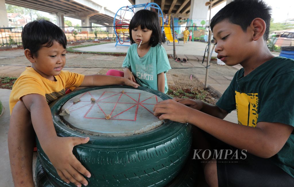 Anak-anak bermain damdas di arena bermain yang selesai dibangun di kolong Tol Becakayu di kawasan Cipinang Melayu, Jakarta Timur, Senin (30/10/2023).  