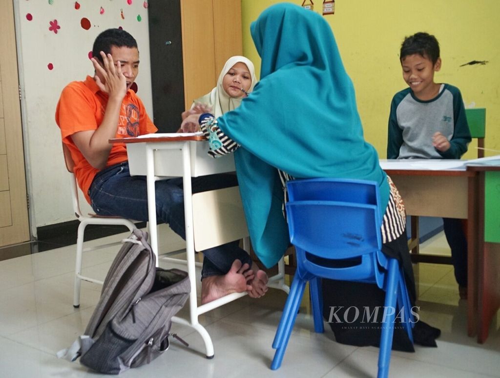 Salah satu pengajar di Pusat Layanan Autis (PLA) Kepulauan Riau melatih anak autis untuk belajar, Selasa (7/5/2019).