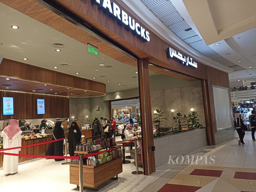 Suasana di depan gerai kopi asal Amerika Serikat yang dibuka di pusat perbelanjaan di Zamzam Tower di Mekkah, Arab Saudi, Jumat (17/6/2022) siang. Saat ini, semakin banyak ditemukan makanan cepat saji dari brand global yang dibuka di Mekkah.
