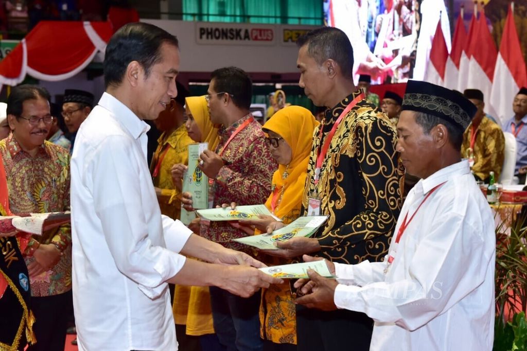 Presiden Joko Widodo menyerahkan sertifikat tanah gratis di GOR Tridharma Gresik, Jawa Timur, Kamis (20/6/2019). Total ada 3.200 sertifikat tanah yang diserahkan untuk warga Gresik